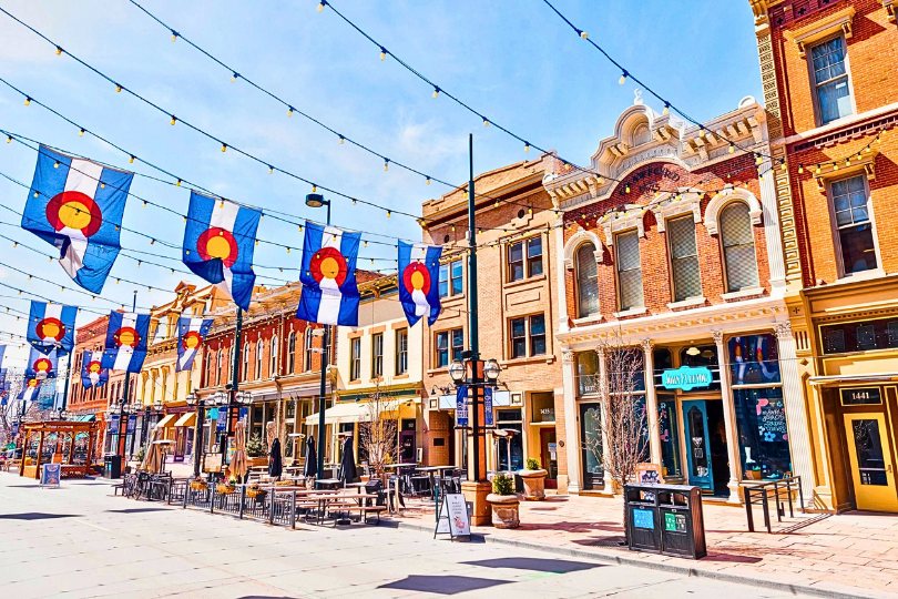 A Colorado main street with historic storefronts and state flags