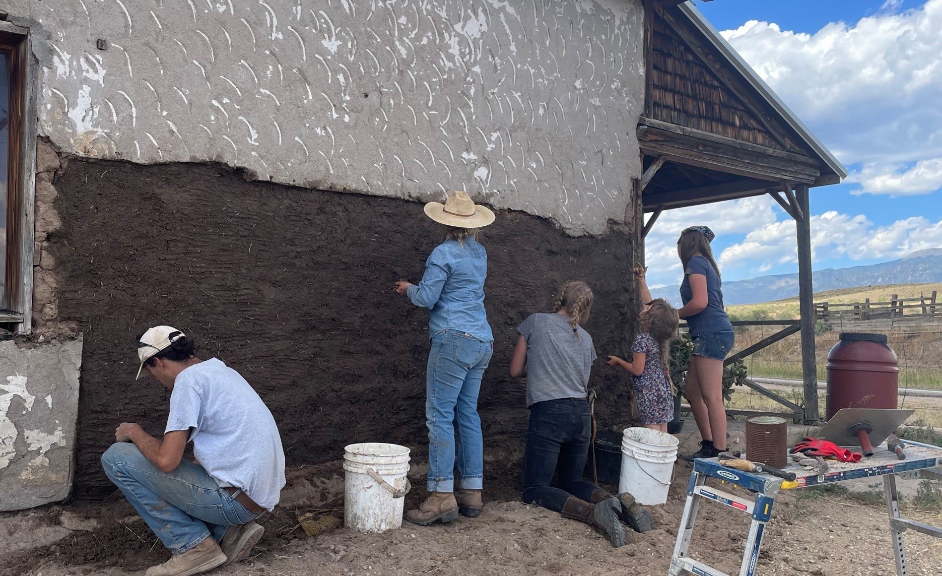 Volunteers repairing an adobe wall at a CPI workshop